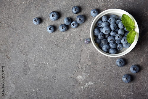 Flat lay composition with juicy and fresh blueberries on color table. Space for text