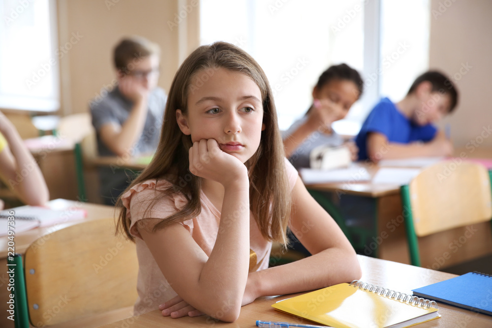 © Africa Studio - Sad girl sitting in classroom. Bullying at school © Africa Studio - Sad girl sitting in classroom. Bullying at school