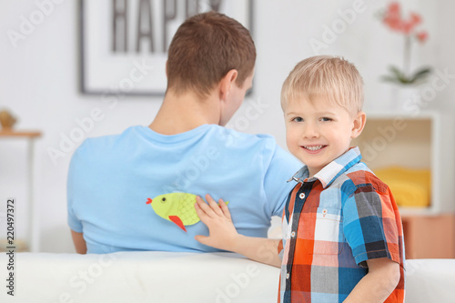Little boy sticking paper f...
