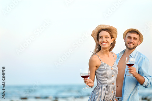 Young couple with glasses of wine on beach © New Africa