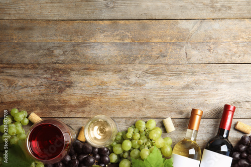 Flat lay composition with fresh ripe juicy grapes and space for text on wooden background