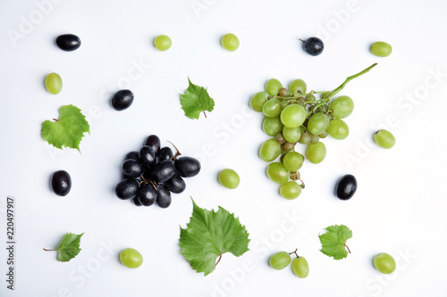 Fresh ripe juicy grapes and leaves on white background, top view