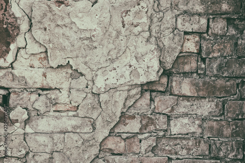 Retro background of old brick wall with fallen off cement plaster