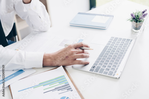 Businessman using laptop computer for budget planner in modern office, white background, Business and Office concept.