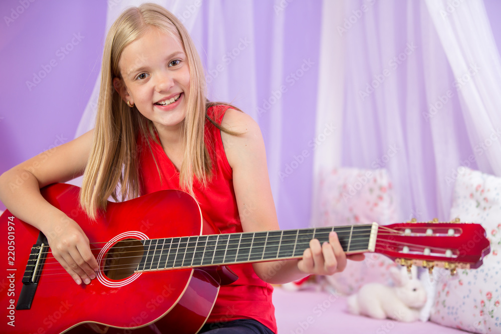 Fototapeta premium Teenage girl with her guitar in her lovely room¨