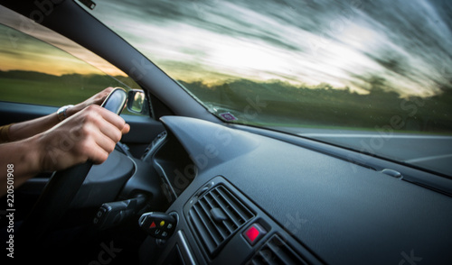 Man driving a car moving fast on a highway (motion blurred image)