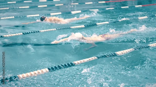 High angle three swimmers having competition in swimming pool tracking shot