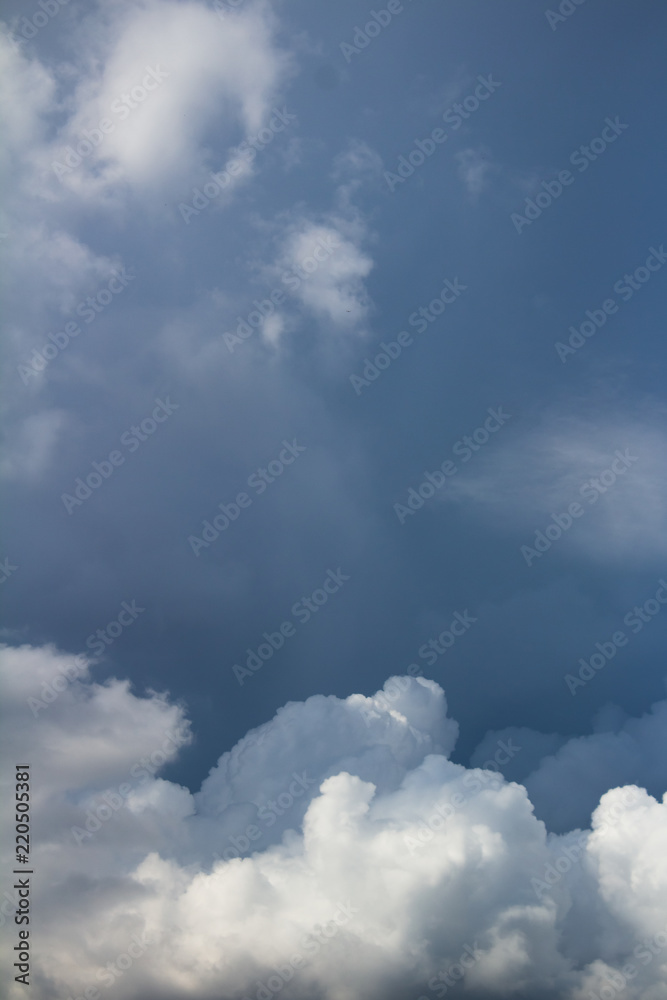 Fototapeta premium white cumulus clouds on dark blue sky vertical photo