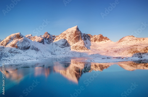 Aerial view at the mountains and reflection on the water surface. Lofoten islands, Norway. Natural landscape during sunrise from air. Drone landscape © biletskiyevgeniy.com