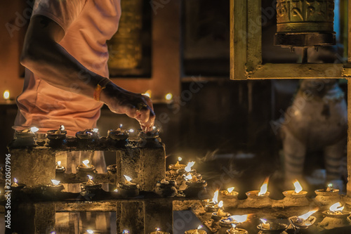 Worshipper lighting candles to celebrate South Asian festival 