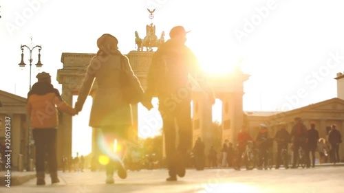 Berlin Brandenburg gate at sunset with tourists on the square