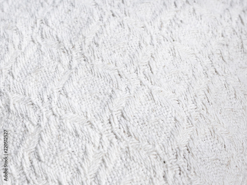 Texture of hand-woven white fabric. Rough threads, prominent textile pattern.