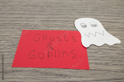Halloween composition, ghosts and goblins handwritten on a red paper