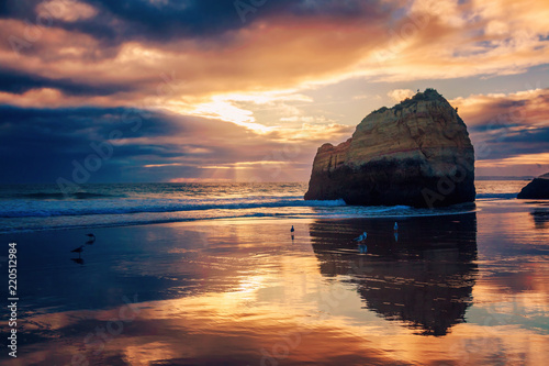 beautiful stunning magical ocean landscape, coast of Portugal, the Algarve at sunset, clouds reflected on the sand