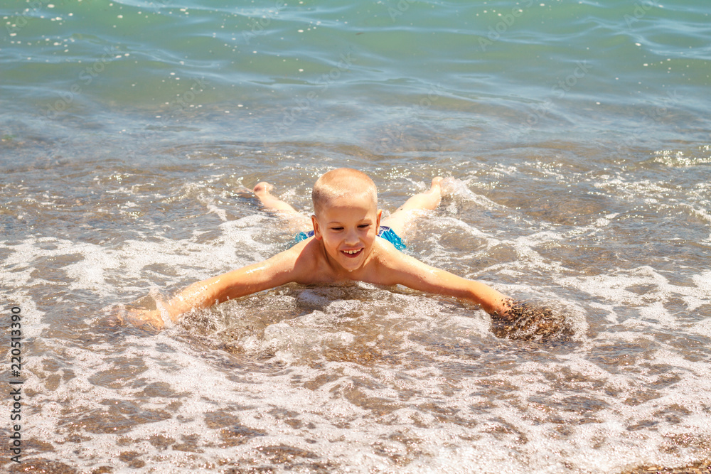 cheerful boy bathes in the sea waves cheerful boy bathes in the sea waves