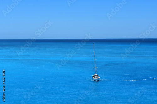 A white yacht sails on the blue sea