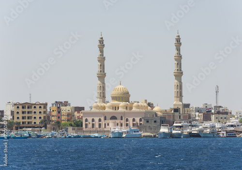 Large mosque in coastal egyptian city with boats