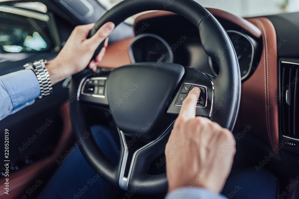 hands pushing button on the steering wheel hands pushing button on the steering wheel