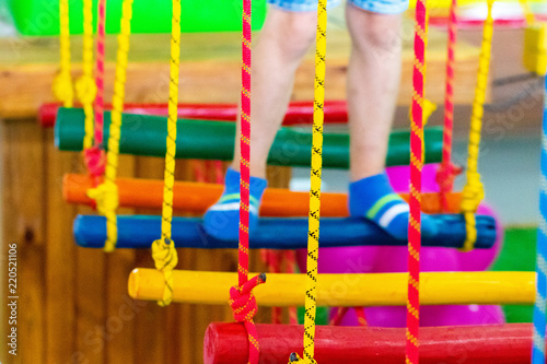 Children's feet at the playground with swinging bridge