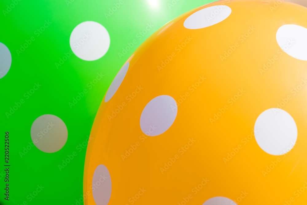 Fototapeta premium Background of green and orange balloons with the white circles on them. The optimistic picture, the symbol of happiness and joy