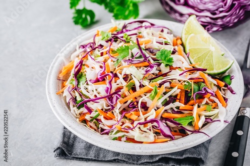 Cilantro lime coleslaw salad with red and white cabbage on stone background