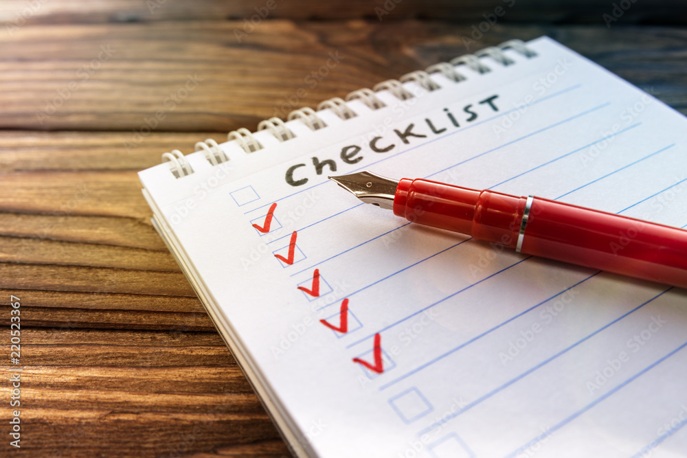 checklist, notepad, fountain pen on the background of a wooden table. Financial planning. checklist, notepad, fountain pen on the background of a wooden table. Financial planning.
