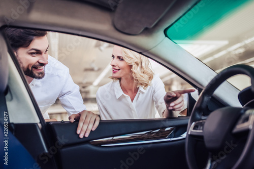 aucasian couple looking at new car © Afshar Tetyana