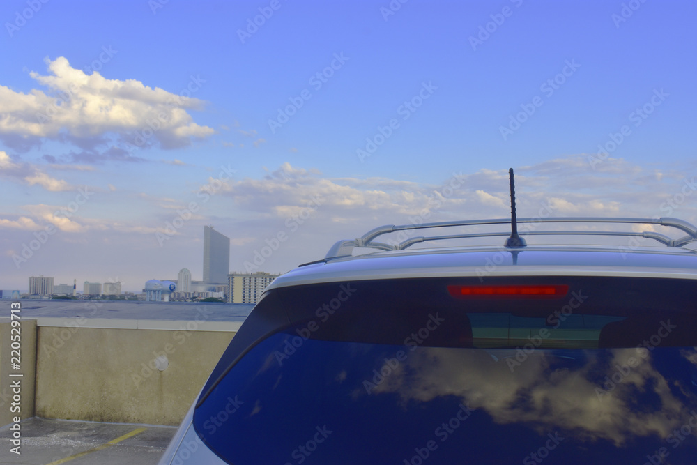 Beautiful sky and city skyline visible over roof of automobile on an Atlantic City rooftop parking lot
