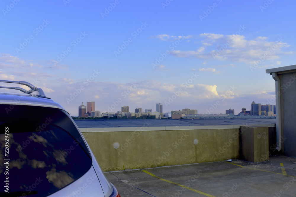 Beautiful sky and city skyline visible over roof of automobile on an Atlantic City rooftop parking lot