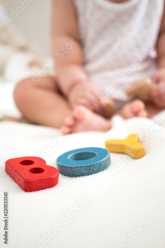 boy text wooden word on blanket with blurred kid foot and copy space background