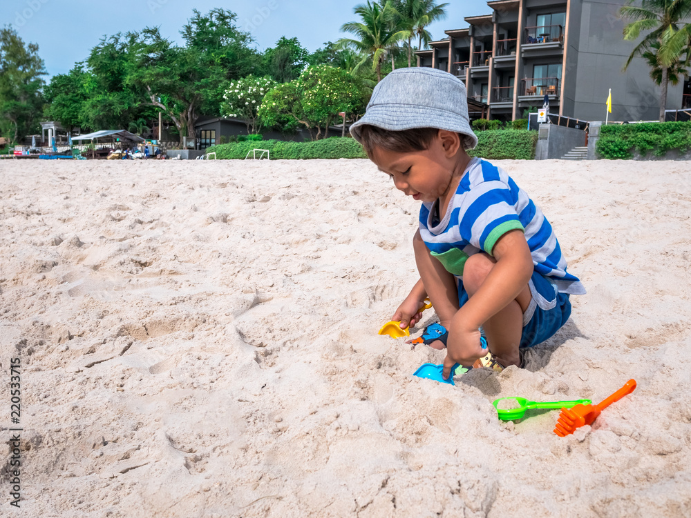 The asia boy two year old toddler playing with beach toys on white sand Hua Hin beach Thailand. The asia boy two year old toddler playing with beach toys on white sand Hua Hin beach Thailand.