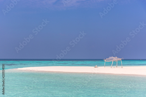 Amazing blue water in a desert island  blue sky day  wood hut