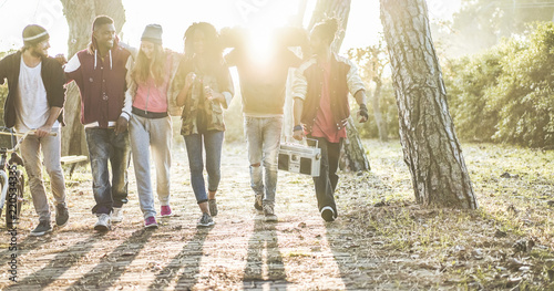 Happy generation z friends walking in city park on fall time