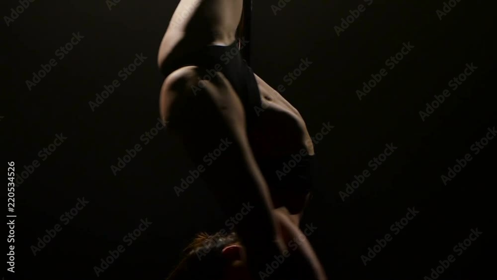 Female poledance on pole at dance night club. Black background. Slow motion. Close up Female poledance on pole at dance night club. Black background. Slow motion. Close up