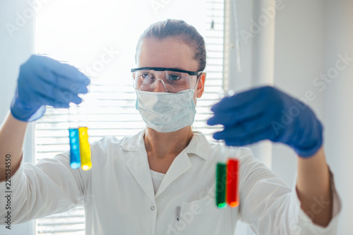 Female chemist checks test tube results