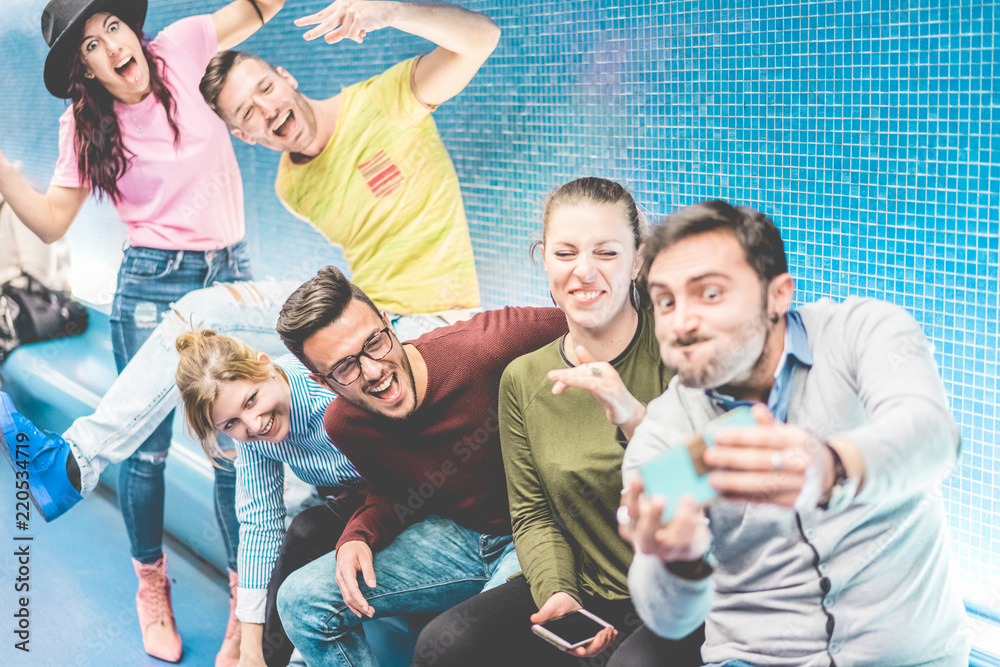 Obraz premium Happy millennials friends making video story feed inside metro underground station