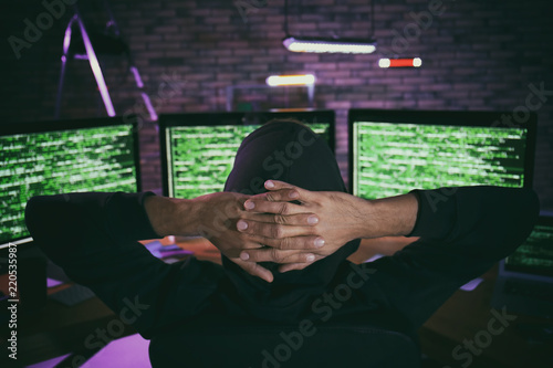 Hacker in dark room with co...