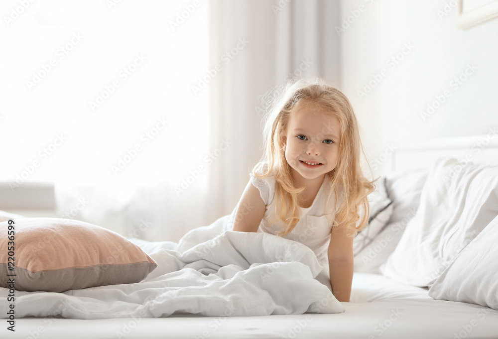 Cute little girl on bed with soft pillows at home Cute little girl on bed with soft pillows at home