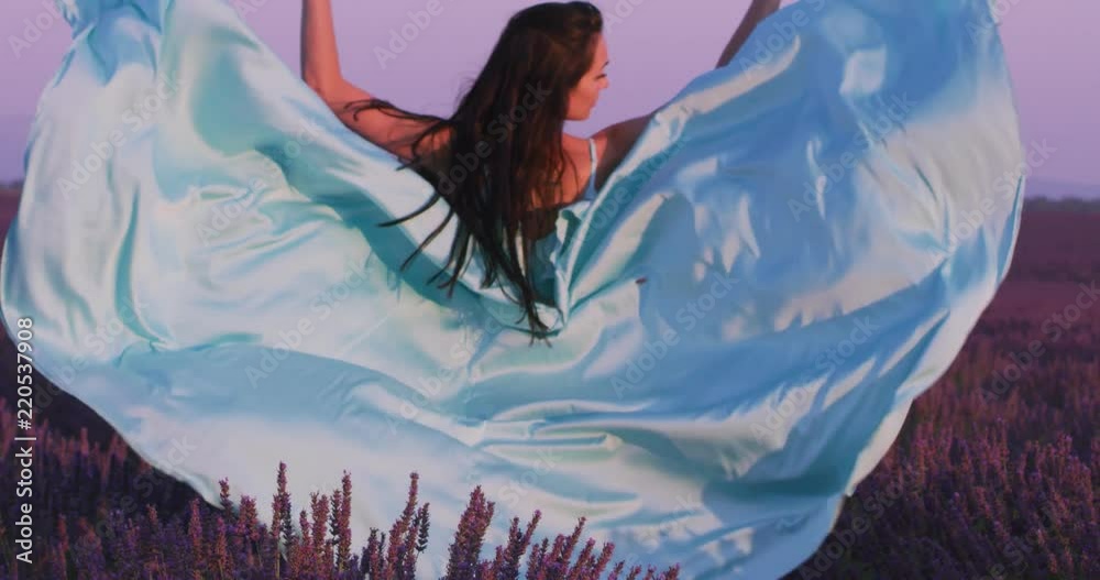 lavander flower field woman in cyand dress having fun and relax on wind in  purple flower field