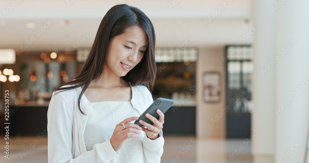 Woman sending sms on cellphone in the park