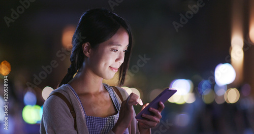 Photography Woman use of smart phone in city at night