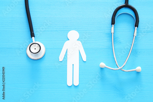 men healf Insurance . concept image of Stethoscope and male figure on wooden table. top view. photo