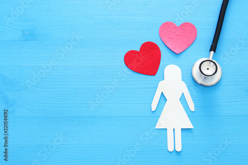 women healf Insurance . concept image of Stethoscope and female figure on wooden table. top view. photo