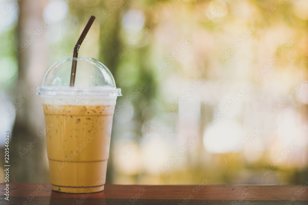 Ice latte coffee on woodern table over nature bokeh background Ice latte coffee on woodern table over nature bokeh background