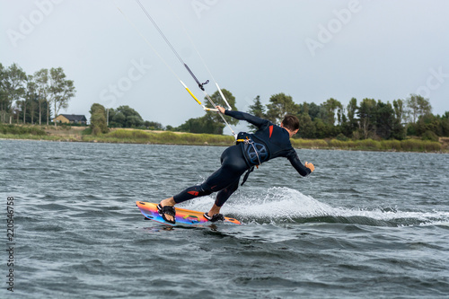 Canvas Print kite surfer in a reverse stunt while surfing over cold water