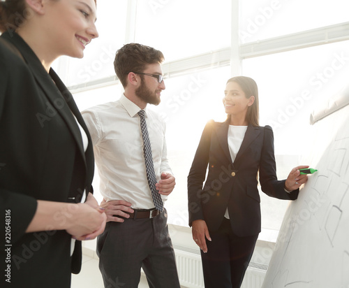 businesswoman pointing marker to flipboard on presentation in office photo