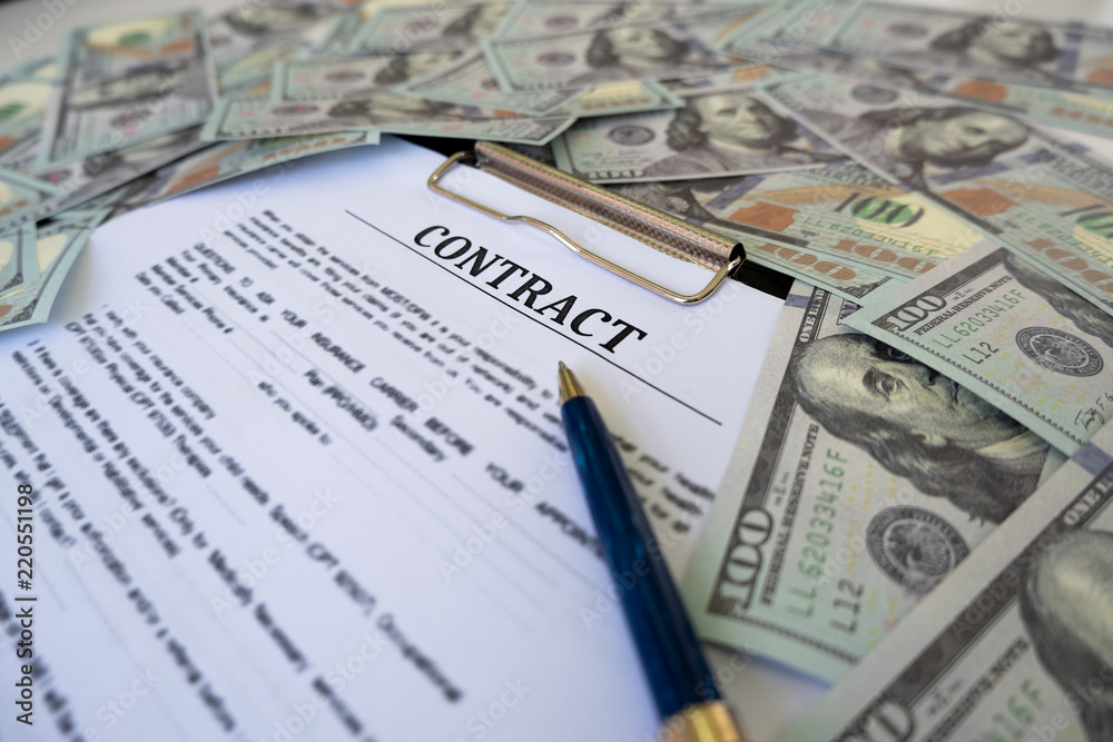 Sign contract for more money, US Dollar banknotes money on printed contract paper and pen to sign Sign contract for more money, US Dollar banknotes money on printed contract paper and pen to sign