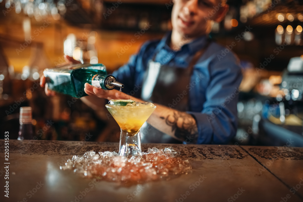 Bartender pours beverage into the glass with ice Bartender pours beverage into the glass with ice