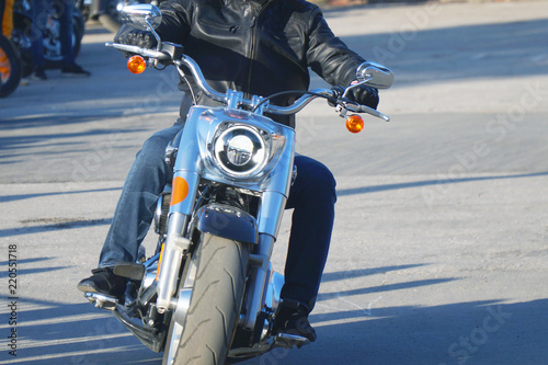 The biker in a leather jacket rides a motorcycle