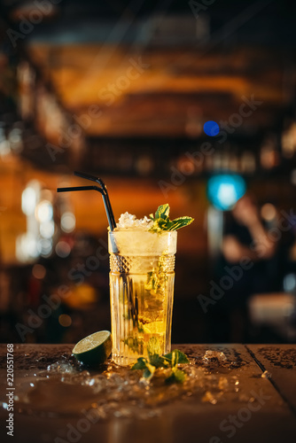 Fresh mojito in a glass and ice on bar counter